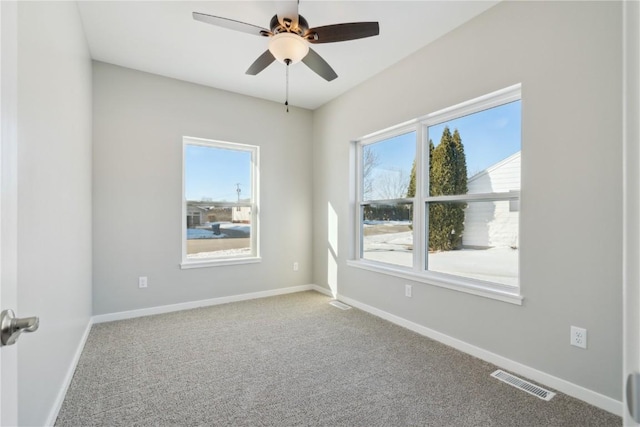 spare room featuring ceiling fan, carpet, visible vents, and baseboards