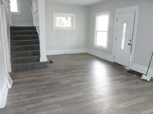 foyer featuring visible vents, stairway, baseboards, and wood finished floors