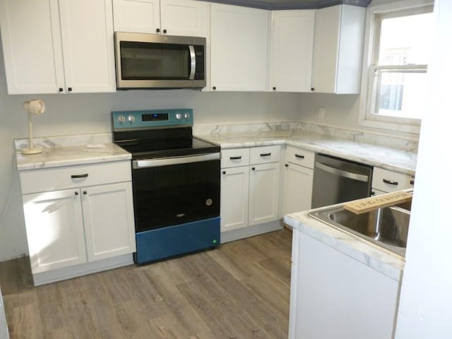 kitchen with white cabinetry, appliances with stainless steel finishes, and a sink