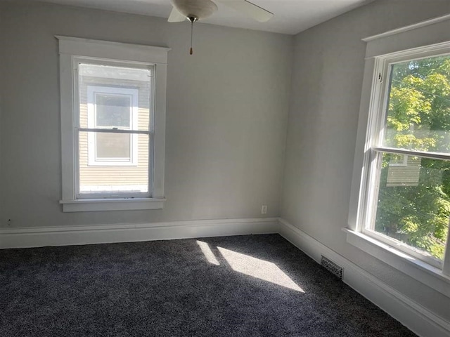 carpeted spare room featuring visible vents and baseboards