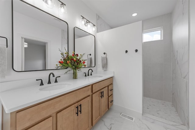 bathroom featuring marble finish floor, visible vents, a sink, and double vanity