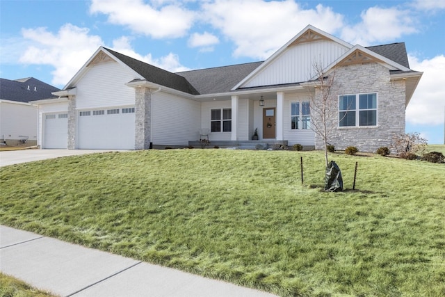 view of front of property featuring covered porch, an attached garage, stone siding, driveway, and a front lawn