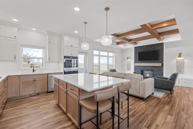 kitchen with stainless steel appliances, tasteful backsplash, light wood-type flooring, and a sink