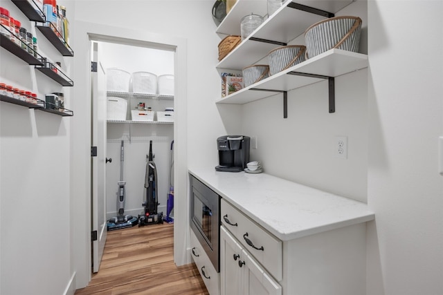 interior space featuring light wood-style floors and stainless steel microwave