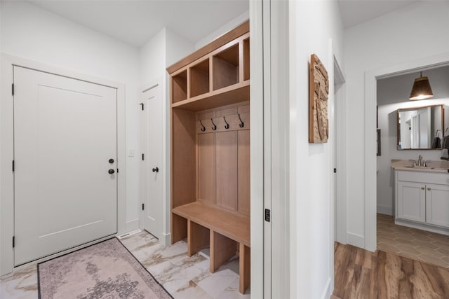 mudroom with marble finish floor and a sink