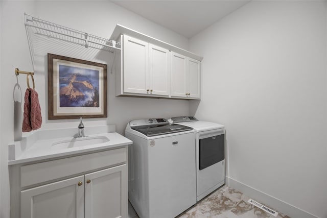 laundry room with a sink, baseboards, washer and dryer, marble finish floor, and cabinet space