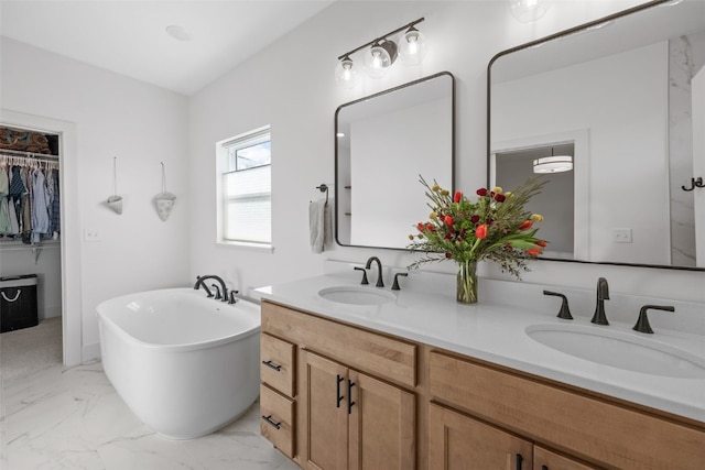 full bathroom with double vanity, marble finish floor, a sink, and a soaking tub