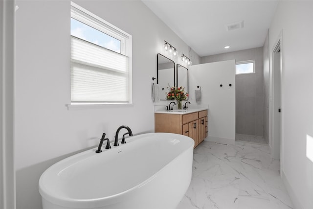 full bath featuring marble finish floor, double vanity, visible vents, a freestanding bath, and a walk in shower