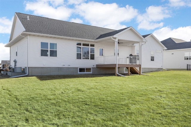 back of house featuring a yard, a shingled roof, and a ceiling fan