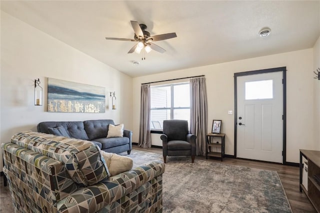 living area featuring lofted ceiling, baseboards, a ceiling fan, and wood finished floors