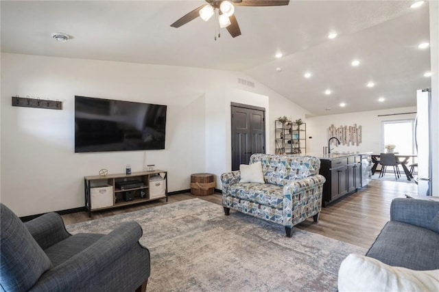 living area with visible vents, a ceiling fan, lofted ceiling, light wood-type flooring, and recessed lighting