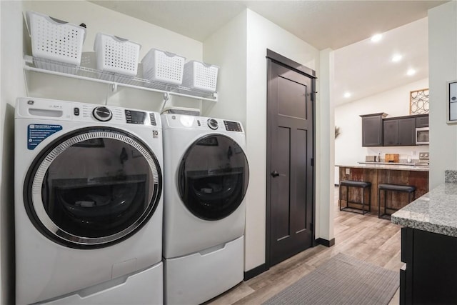 laundry area with light wood-type flooring, laundry area, recessed lighting, and separate washer and dryer