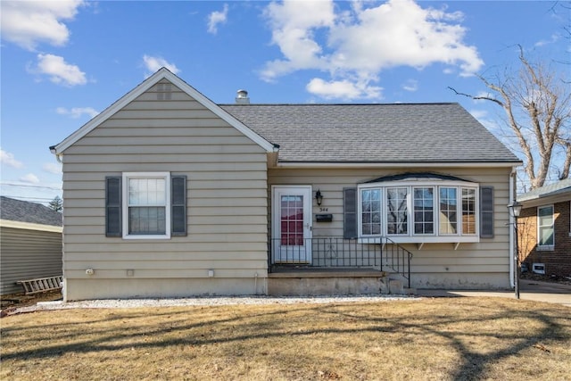 bungalow-style house with a front lawn and roof with shingles