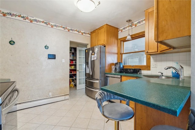 kitchen featuring a baseboard radiator, a sink, appliances with stainless steel finishes, tasteful backsplash, and dark countertops