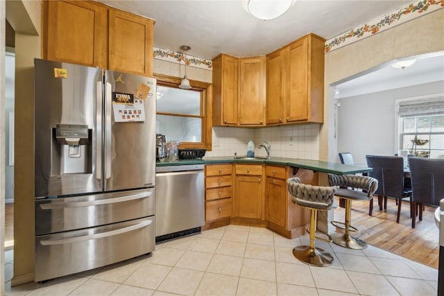 kitchen with dark countertops, light tile patterned floors, tasteful backsplash, and appliances with stainless steel finishes