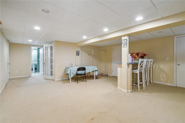 living area featuring carpet floors, baseboards, a drop ceiling, and recessed lighting