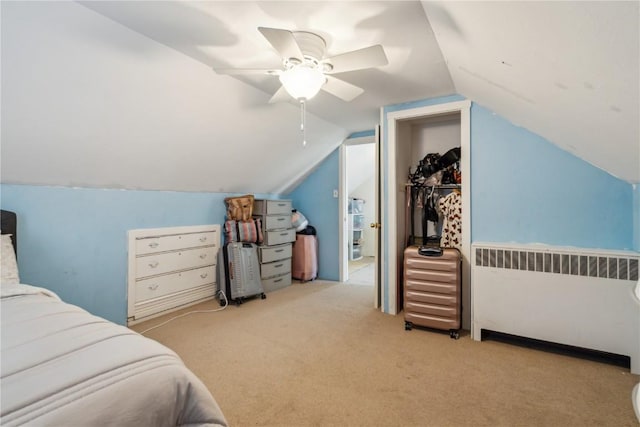 carpeted bedroom with vaulted ceiling, ceiling fan, and radiator heating unit