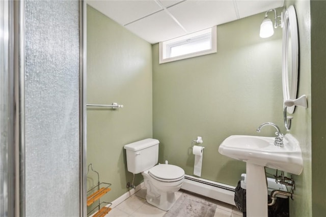 bathroom featuring toilet, tile patterned flooring, a baseboard heating unit, and baseboards