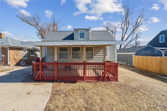 bungalow-style house featuring covered porch and fence