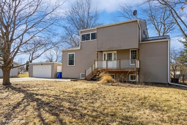 rear view of property with a garage, an outbuilding, concrete driveway, and stairs