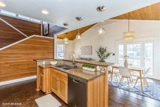 kitchen with a center island with sink, lofted ceiling, hanging light fixtures, a sink, and dishwasher