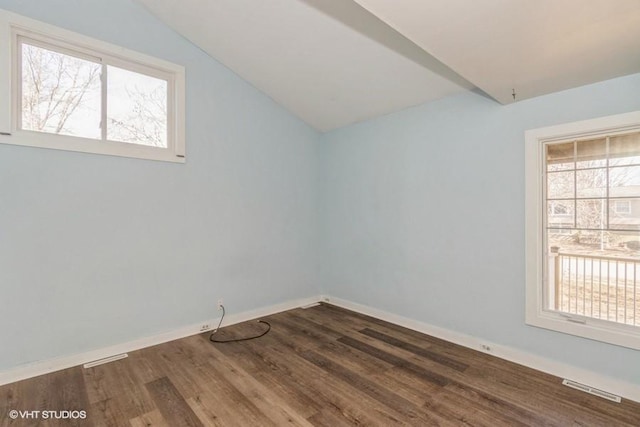 interior space featuring lofted ceiling, visible vents, baseboards, and wood finished floors