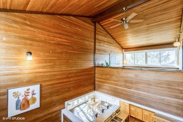 interior space with vaulted ceiling with beams, ceiling fan, wooden walls, wood ceiling, and a sauna