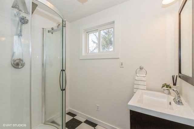 bathroom with baseboards, a shower stall, vanity, and tile patterned floors