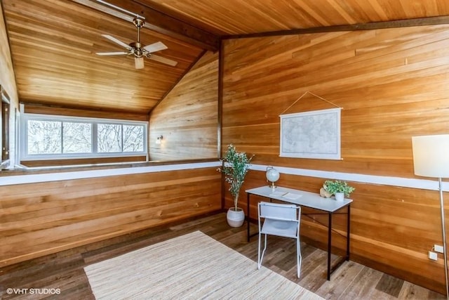 office space with lofted ceiling with beams, wooden walls, wood finished floors, a ceiling fan, and wood ceiling