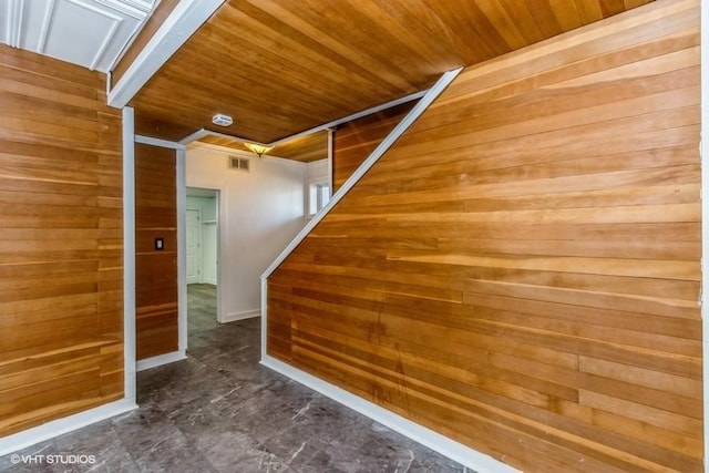 additional living space with visible vents, wood walls, and wood ceiling