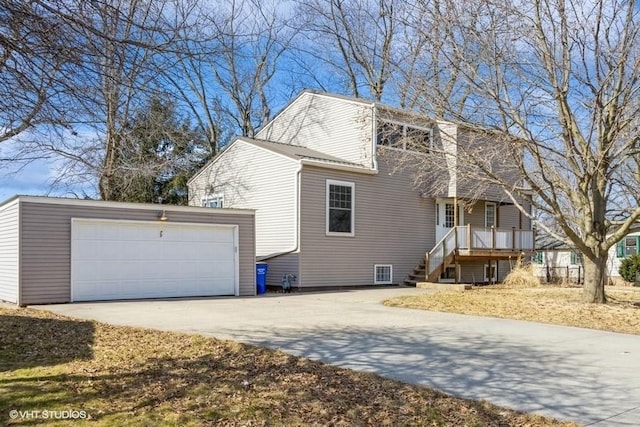 view of side of home featuring a garage and concrete driveway