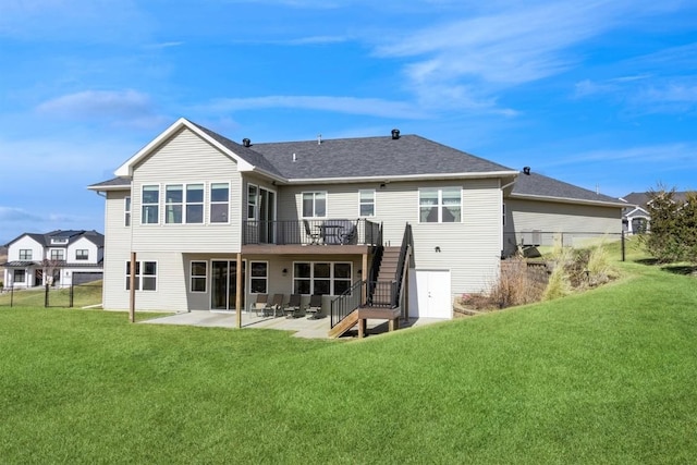 rear view of property with a lawn, stairway, fence, a wooden deck, and a patio area