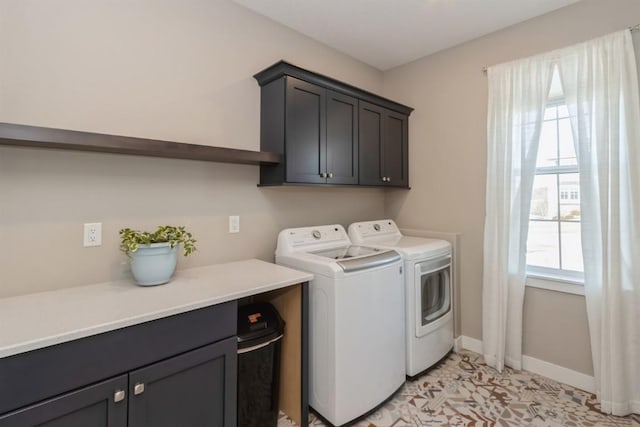 laundry area featuring independent washer and dryer, cabinet space, and baseboards