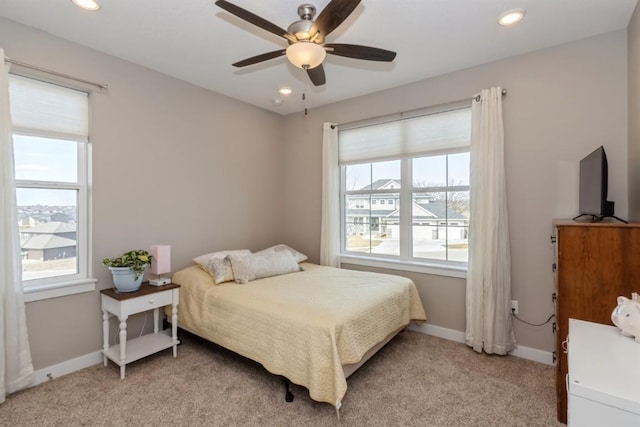 bedroom featuring recessed lighting, multiple windows, baseboards, and light colored carpet