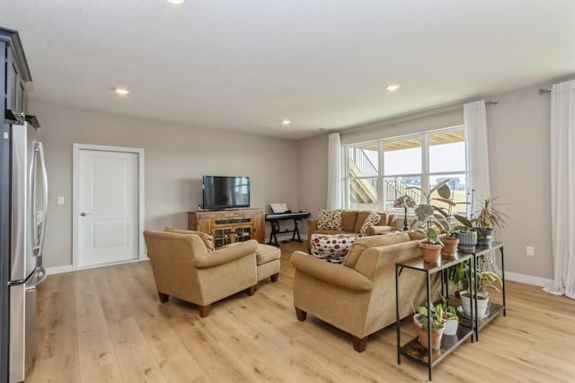 living room featuring recessed lighting, light wood-style flooring, and baseboards