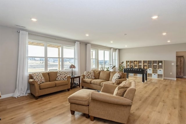 living room with baseboards, light wood-style flooring, and recessed lighting