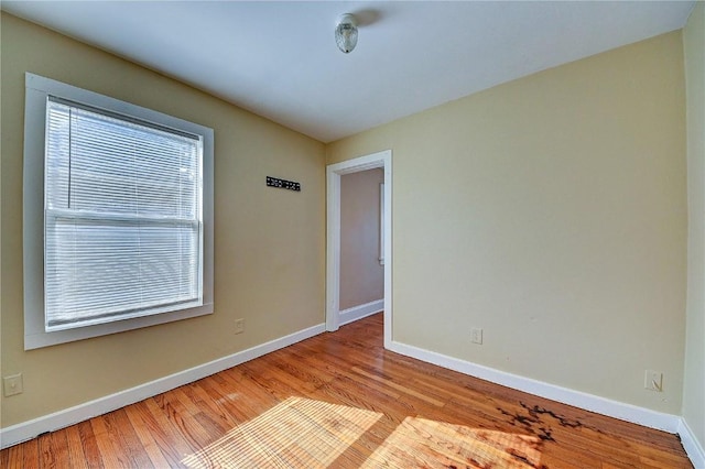 empty room with baseboards and wood finished floors