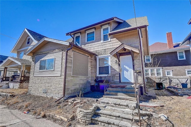 view of front of property with stone siding and fence