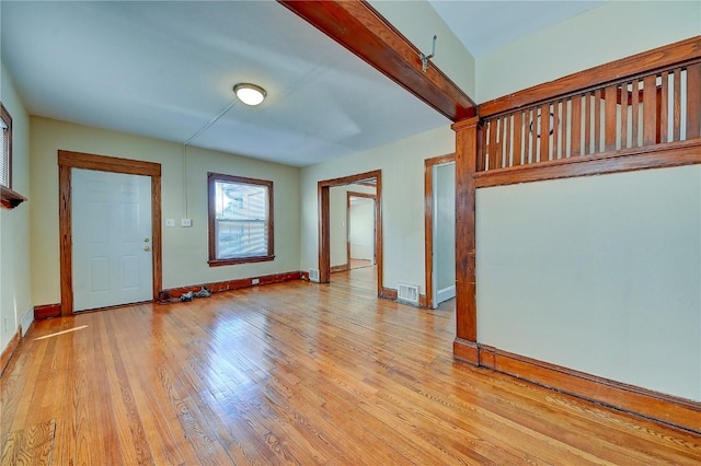 interior space featuring light wood-style floors, baseboards, and visible vents