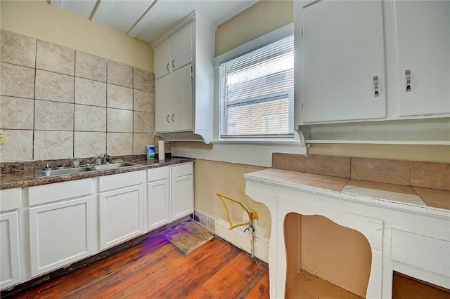 kitchen with dark wood-style flooring, white cabinetry, a sink, and visible vents