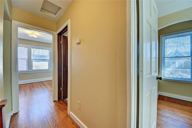 hall featuring baseboards and wood finished floors