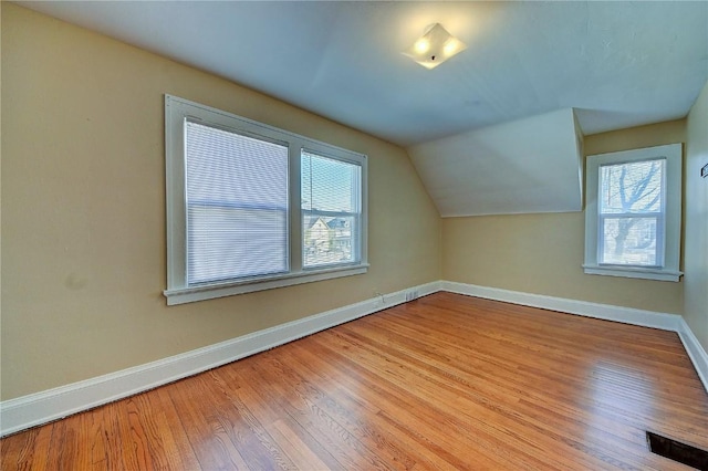 additional living space featuring lofted ceiling, wood-type flooring, and baseboards