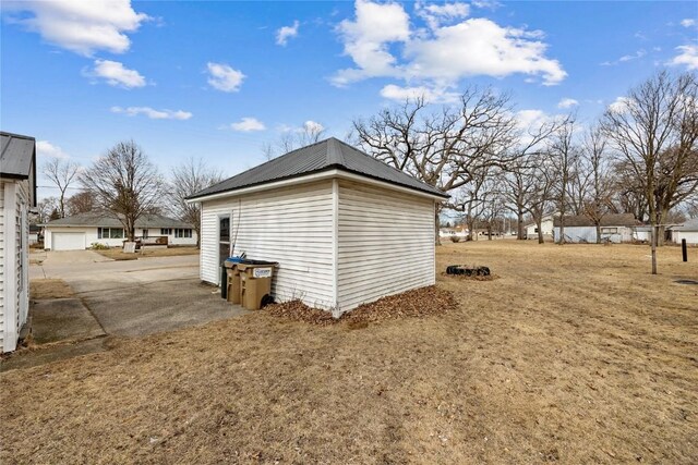 view of property exterior featuring metal roof and a detached garage