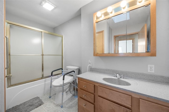 full bath with combined bath / shower with glass door, vanity, toilet, and tile patterned floors