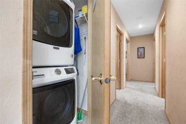 laundry room featuring carpet floors, stacked washer / dryer, laundry area, and baseboards