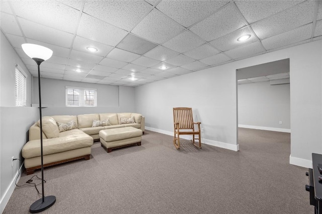 living room featuring baseboards, a drop ceiling, and recessed lighting