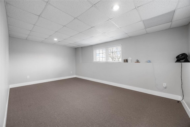 carpeted spare room with a paneled ceiling and baseboards