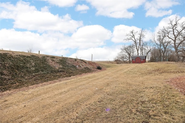 view of yard with driveway and a rural view