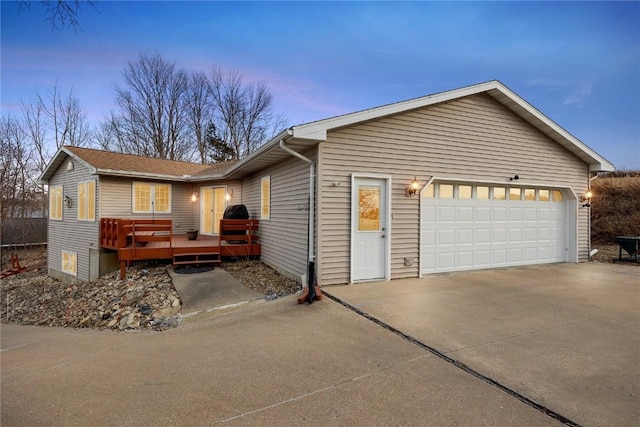 view of front facade featuring a garage, a deck, and concrete driveway