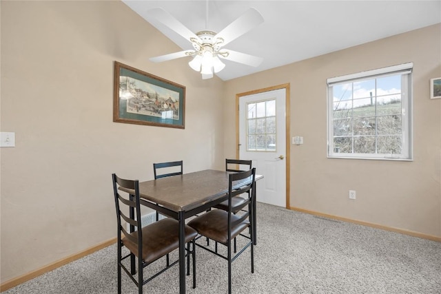 dining space with a ceiling fan, light carpet, and baseboards